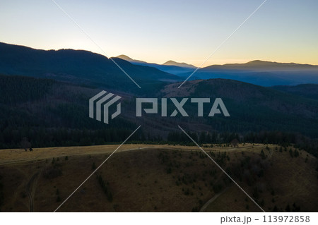 Beautiful mountain panoramic landscape with hazy peaks and foggy valley at sunset Beautiful mountain panoramic landscape with hazy peaks and foggy valley at sunset 113972858