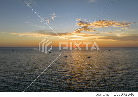 Aerial view of small yachts at sunset floating on sea waves with ripple surface. Motor boats recreation on ocean surface 113972946