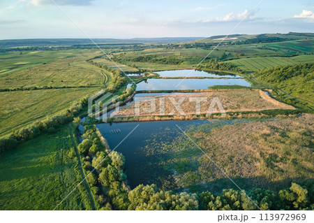 Aerial view of fish hetching pond with blue water in aquacultural area Aerial view of fish hetching pond with blue water in aquacultural area 113972969