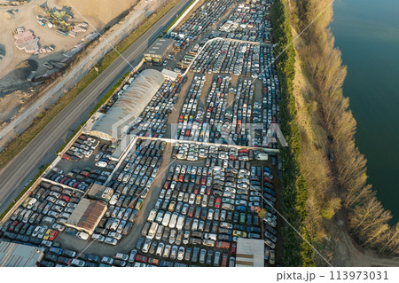 Aerial view of big parking lot of junkyard with rows of discarded broken cars. Recycling of old vehicles 113973031