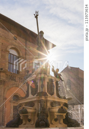 Sunrays pierce the Neptune Fountain in Bologna, creating dazzling effects on water droplets 113973634