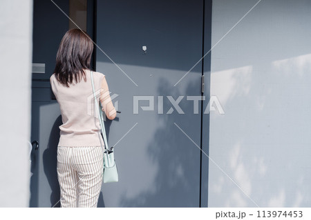 家の玄関ドアを開ける若い女性 家の玄関ドアを開ける若い女性 113974453
