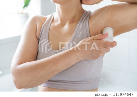 Closeup woman applying natural crystal alum deodorant in modern bathroom. Eco friendly natural beauty and hygiene cosmetics. Zero waste, sustainable, alternative body care concept. Selective focus Closeup woman applying natural crystal alum deodorant in modern bathroom. Eco friendly natural beauty and hygiene cosmetics. Zero waste, sustainable, alternative body care concept. Selective focus 113974647