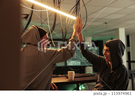 Successful cyberattack, happy hackers giving high five, hacking server, stealing business data. Scammers cracking computer system password, breaking into banking account at night time 113974961