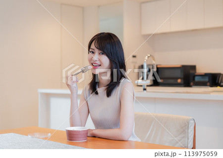 家でコンビニ弁当を食べる若い女性 113975059