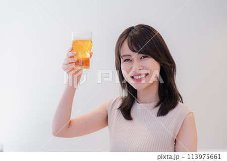 笑顔でビールを飲む若い女性 113975661