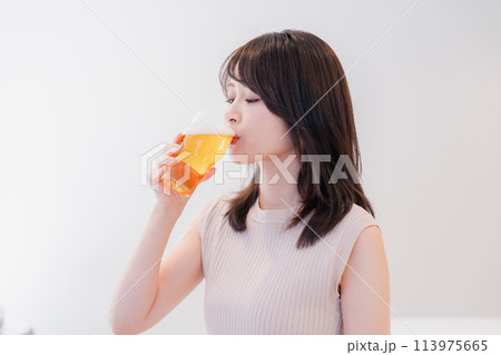 笑顔でビールを飲む若い女性 113975665