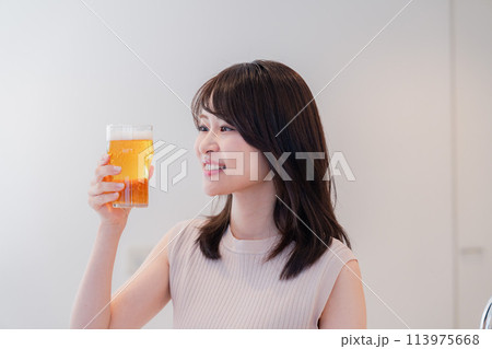笑顔でビールを飲む若い女性 113975668