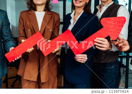 Business teamwork hold a red arrow as growing, successful and profit concept 113975924