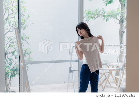 家でファッションの組み合わせを考える若い女性 113976263