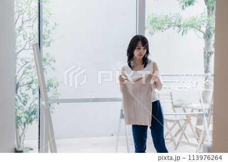 家でファッションの組み合わせを考える若い女性 家でファッションの組み合わせを考える若い女性 113976264