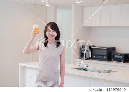 家事をしながらアルコールを飲む若い女性 家事をしながらアルコールを飲む若い女性 113976649
