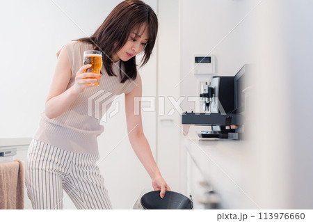 家事をしながらアルコールを飲む若い女性 家事をしながらアルコールを飲む若い女性 113976660