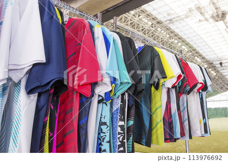 カラフルなシャツ　ラックに掛けたウェア　スポーツショップ　イメージ素材 113976692