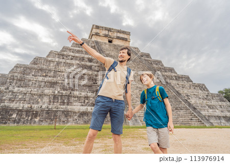 Father and son tourists observing the old pyramid and temple of the castle of the Mayan architecture known as Chichen Itza these are the ruins of this ancient pre-columbian civilization and part of Father and son tourists observing the old pyramid and temple of the castle of the Mayan architecture known as Chichen Itza these are the ruins of this ancient pre-columbian civilization and part of 113976914