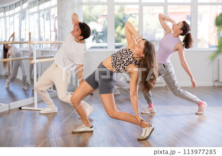 Young girl practicing hip-hop dance in training hall in group Young girl practicing hip-hop dance in training hall in group 113977285