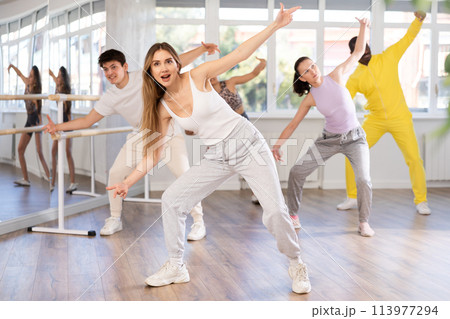 Young girl practicing hip-hop dance in training hall in group Young girl practicing hip-hop dance in training hall in group 113977294