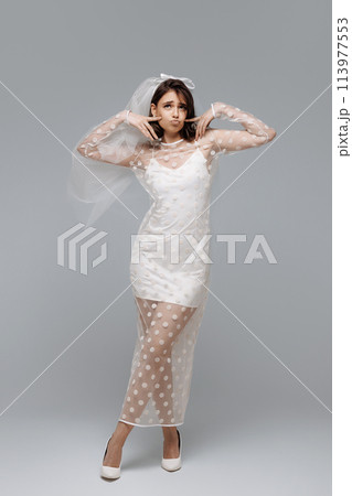 A woman in a wedding dress is posing for a picture A woman in a wedding dress is posing for a picture 113977553