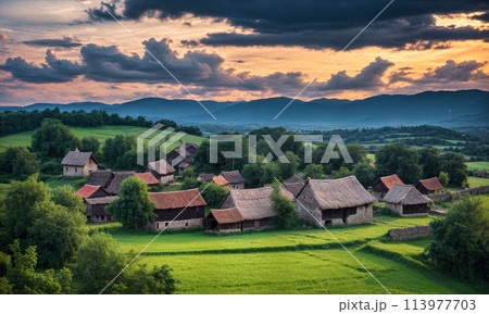 Panoramic top view of an old small abandoned ruined village on the hills with thatched roof huts at sunset with clouds in the sky Panoramic top view of an old small abandoned ruined village on the hills with thatched roof huts at sunset with clouds in the sky 113977703