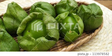 籠に入った新鮮な殻付きトマティーヨ6個　（メキシコ） 113978582