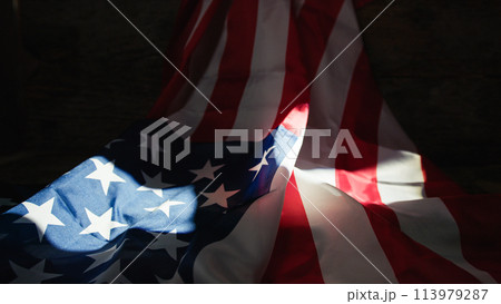 USA flag under lit by a window light  113979287