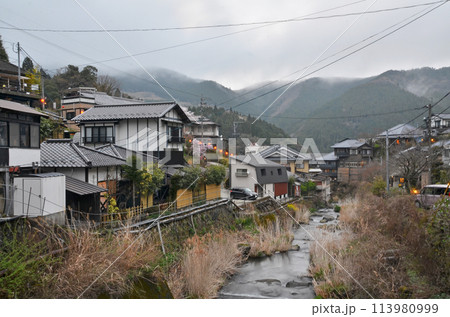 山あいの小川沿いの風情ある町並み 曇り空のもと、ひっそりと佇む温泉街 山あいの小川沿いの風情ある町並み 曇り空のもと、ひっそりと佇む温泉街 113980999