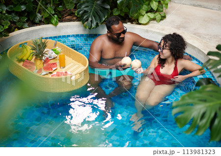 Young couple toasting in swimming pool Young couple toasting in swimming pool 113981323