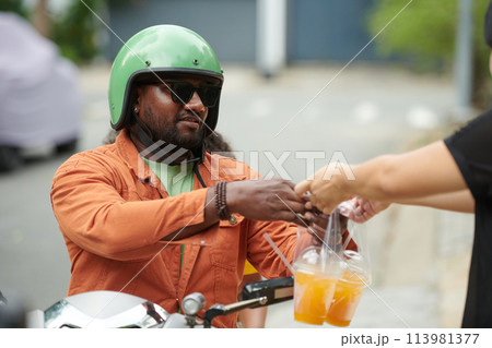 Young man buying two glasses of juice 113981377