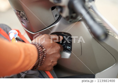 Bike owner pushing button on panel Bike owner pushing button on panel 113981400