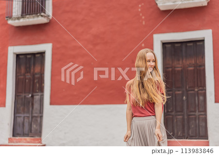 Woman tourist explores the vibrant streets of Valladolid, Mexico, immersing herself in the rich culture and colorful architecture of this charming colonial town Woman tourist explores the vibrant streets of Valladolid, Mexico, immersing herself in the rich culture and colorful architecture of this charming colonial town 113983846