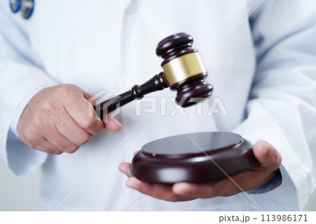 Asian doctor holding court hammer for and crime law justice, forensic medicine. 113986171