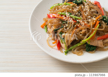 japchae or stir-fried Korean vermicelli noodles with vegetables and pork topped with white sesame 113987066