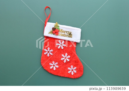 red wool winter sock on green background, christmas decoration 113989639