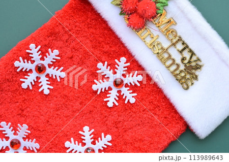 red wool winter sock on green background, christmas decoration 113989643