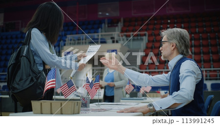African American girl talks with polling officer and takes bulletin 113991245