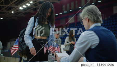 African American girl talks with polling officer and takes bulletin 113991280
