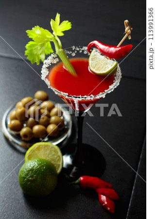 Bloody Mary cocktail with celery, lime, red pepper, and green olives. 113991366