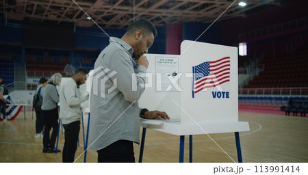 African American voter with bulletin comes to voting booth 113991414