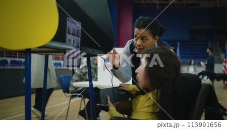 Female US voter with SMA uses remote buttons and votes on tablet Female US voter with SMA uses remote buttons and votes on tablet 113991656