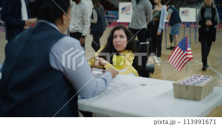 Woman with SMA comes and talks with polling officer Woman with SMA comes and talks with polling officer 113991671