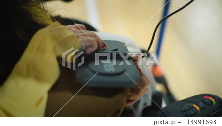 Close up of woman with disability voting at polling station using remote control 113991693