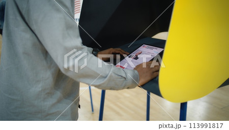 African American US citizen uses tablet computer for voting in voting booth African American US citizen uses tablet computer for voting in voting booth 113991817