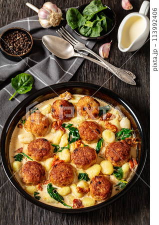 tuscan chicken meatballs with gnocchi in a dish 113992406