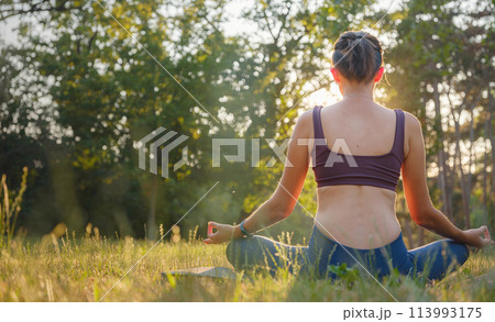 Young asian woman doing meditation in morning or evening at park, healthy woman relaxing and practicing yoga at city park. Mindfulness, destress, Healthy habits and balance concept Young asian woman doing meditation in morning or evening at park, healthy woman relaxing and practicing yoga at city park. Mindfulness, destress, Healthy habits and balance concept 113993175