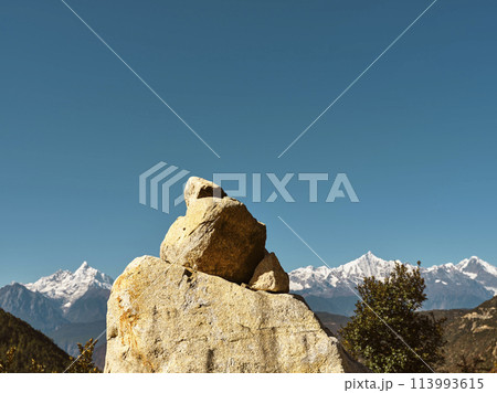 huge prayer stone with meili snow mountain in background in china's yunnan province huge prayer stone with meili snow mountain in background in china's yunnan province 113993615