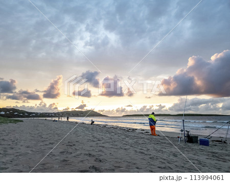 20 man are competing in a fishing competition on the beach. 20 man are competing in a fishing competition on the beach. 113994061