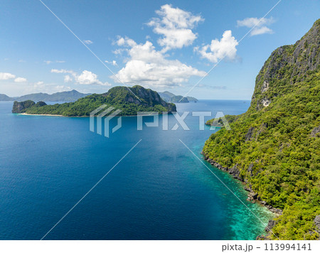 Blue sea in Cadlao and Helicopter Island. Blue sky and clouds. El Nido, Palawan. Philippines. Blue sea in Cadlao and Helicopter Island. Blue sky and clouds. El Nido, Palawan. Philippines. 113994141