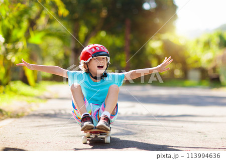 Kid with skateboard. Child riding skate board. 113994636