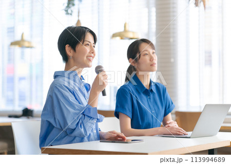 マイクを持って質問をする女性 113994689