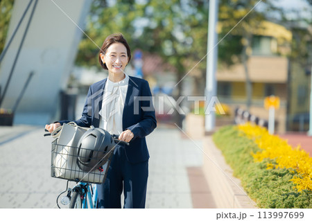 自転車に乗って通勤するミドル女性 自転車に乗って通勤するミドル女性 113997699